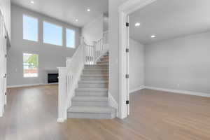 Staircase with a high ceiling and wood-type flooring