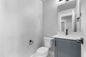 Bathroom featuring toilet, vanity, and tile patterned floors