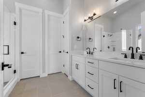 Bathroom with vanity, an enclosed shower, and tile patterned flooring