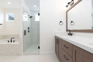 Bathroom featuring vanity and separate shower and tub