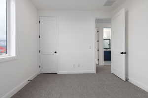 Unfurnished bedroom with light carpet