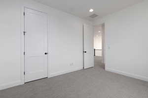 Unfurnished bedroom featuring light colored carpet