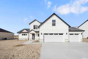 Modern farmhouse with central air condition unit and a garage