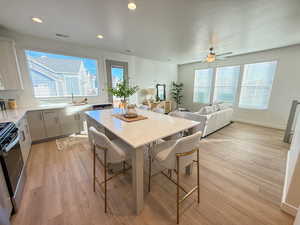 Dining room with ceiling fan, sink, and light wood-type flooring