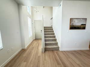 Foyer entrance featuring an inviting chandelier and light hardwood / wood-style flooring