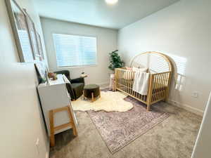 Bedroom with carpet and a crib