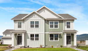 View of front facade with a garage, a front yard, and a mountain view