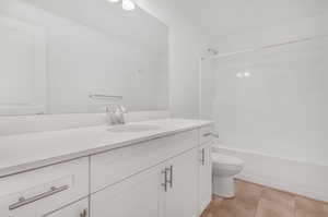 Full bathroom featuring toilet, shower / washtub combination, vanity, and tile patterned floors