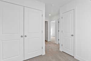 Unfurnished bedroom featuring a closet and light carpet