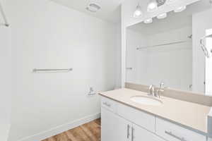 Bathroom featuring wood-type flooring, a shower, and vanity