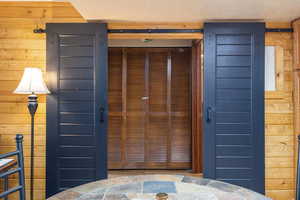 Entryway featuring wood walls