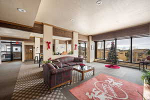 Carpeted living room with a textured ceiling