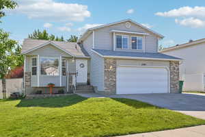 View of property featuring a garage and a front yard