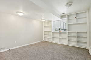 Carpeted spare room featuring a textured ceiling