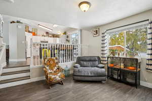 Living area with dark hardwood / wood-style floors and vaulted ceiling