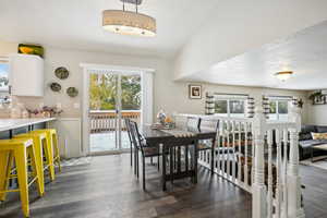 Dining room featuring lofted ceiling, dark hardwood / wood-style floors, and a healthy amount of sunlight