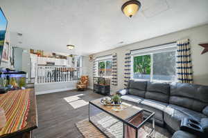 Living room with dark wood-type flooring and a textured ceiling