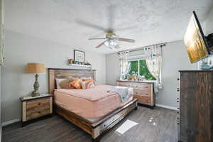 Bedroom featuring a textured ceiling, dark hardwood / wood-style floors, and ceiling fan