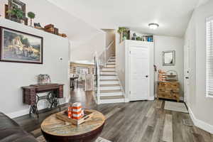 Entryway featuring wood-type flooring and lofted ceiling