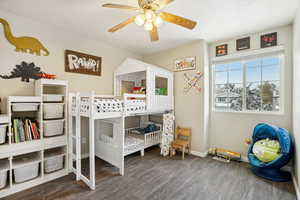 Bedroom with dark hardwood / wood-style floors and ceiling fan