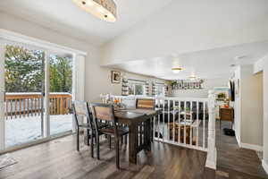 Dining area with dark wood-type flooring and lofted ceiling