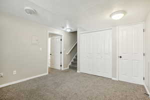 Interior space with a textured ceiling and carpet floors