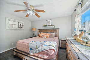 Bedroom with ceiling fan and dark hardwood / wood-style floors