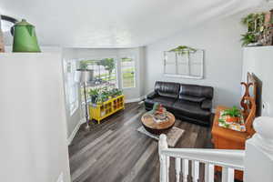 Living room featuring dark hardwood / wood-style flooring and vaulted ceiling