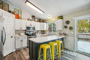 Kitchen with a kitchen bar, kitchen peninsula, lofted ceiling, and appliances with stainless steel finishes