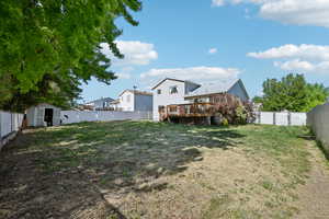 View of yard featuring a storage unit and a wooden deck