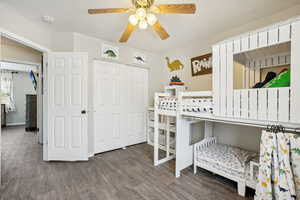 Bedroom with a closet, ceiling fan, and dark hardwood / wood-style flooring