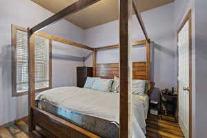 Bedroom with dark hardwood / wood-style flooring and lofted ceiling