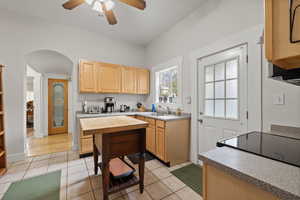 Kitchen with light brown cabinetry, light tile patterned floors, and ceiling fan