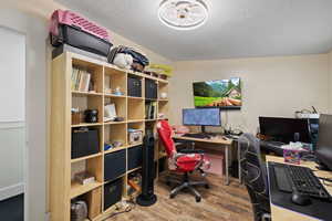 Office space featuring a textured ceiling, wood-type flooring, and vaulted ceiling - 2nd bedroom