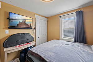 Bedroom with multiple windows and a textured ceiling - 3rd bedroom