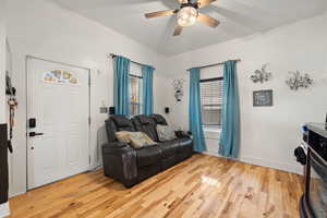 Living room with light hardwood / wood-style floors and ceiling fan