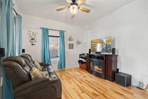 Living room featuring ceiling fan and light hardwood / wood-style floors, 10' ceilings