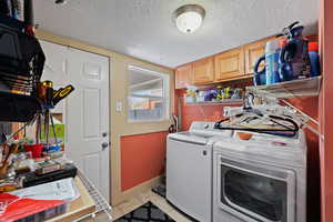 Laundry area featuring washer and dryer and a textured ceiling