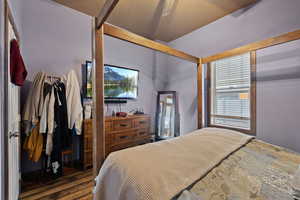 Bedroom with ceiling fan and dark wood-type flooring