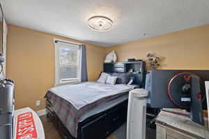 Bedroom featuring dark wood-type flooring and a textured ceiling - 3rd bedroom