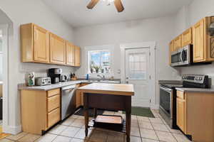 Kitchen featuring light brown cabinets, sink, stainless steel appliances, and light tile patterned flooring