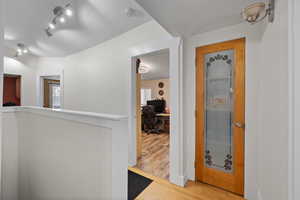 Corridor featuring hardwood / wood-style floors and a textured ceiling