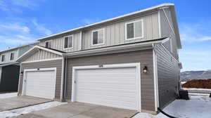 Snow covered garage with central AC and a mountain view