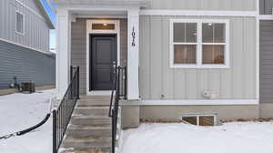 Snow covered property entrance with cooling unit