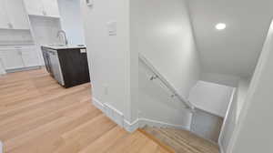 Stairs with sink and wood-type flooring