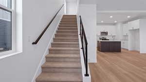 Stairs featuring sink and hardwood / wood-style flooring