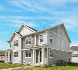 Back of house with central air condition unit and a lawn