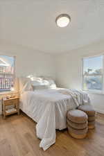 Bedroom with a textured ceiling and light hardwood / wood-style flooring