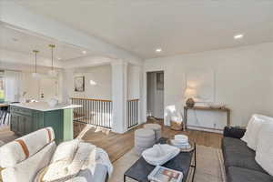 Living room featuring light wood-type flooring and decorative columns