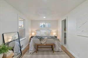 Bedroom with light hardwood / wood-style floors and a textured ceiling